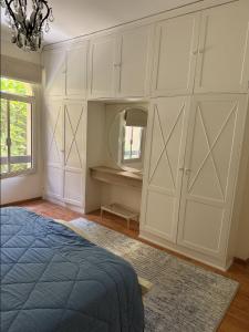 a bedroom with white cabinets and a mirror at CityView Nest in Kafr Ghaţāţī