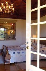 ein Schlafzimmer mit einem Bett, einem Kronleuchter und einer Tür in der Unterkunft Splendid Ponte De Lima Villa 6 Bedrooms Villa Coura Coura Valley Views in Ponte de Lima