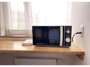 a microwave sitting on top of a wooden counter at Hotel Hanafuji Inn - Vacation STAY 61010v in Nakafurano