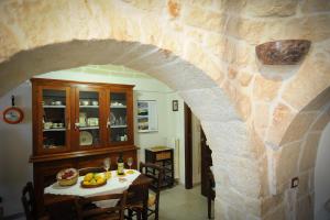 a dining room with a table and a stone wall at Trullo Di Tagaro in Locorotondo
