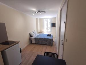 Un dormitorio con una cama y una mesa en una habitación. en BudgetBnb Hyeres 3, en Hyères
