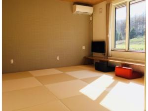 an empty room with a large window and a red chair at Hotel Hanafuji Inn - Vacation STAY 60993v in Nakafurano