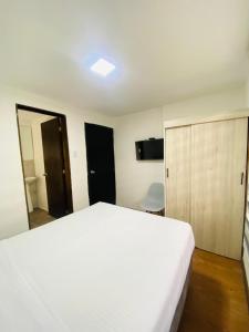 a bedroom with a white bed and a mirror at Casa Boutique Punto 26 in Bogotá +6 photos