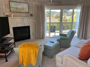 a living room with a couch and a television at Almost Eden Guesthouse in Carmel