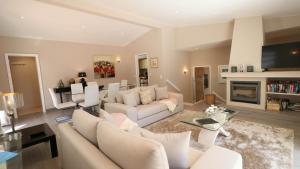 a living room with white furniture and a fireplace at Beautiful Portuguese Villa Casa Das Buganvillas 3 Bedrooms Close To Praca Private Pool Vale Do Lobo in Vale do Lobo