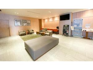 a hospital room with a bed and chairs and a tv at Smile Hotel Premium Sapporo Susukino - Vacation STAY 64521v in Sapporo