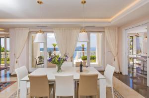ein Esszimmer mit einem weißen Tisch und Stühlen in der Unterkunft Beautiful Dubrovnik Villa 5 Bedrooms Villa Gold Dubrovnik Stylish Furnishings Wonderful Sea Views Orasac in Orasac