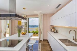 eine Küche mit weißen Arbeitsplatten und Meerblick in der Unterkunft Beautiful Dubrovnik Villa 5 Bedrooms Villa Gold Dubrovnik Stylish Furnishings Wonderful Sea Views Orasac in Orasac