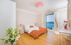 ein weißes Schlafzimmer mit einem Bett und einem großen Fenster in der Unterkunft Beautiful Dubrovnik Villa 5 Bedrooms Villa Gold Dubrovnik Stylish Furnishings Wonderful Sea Views Orasac in Orasac