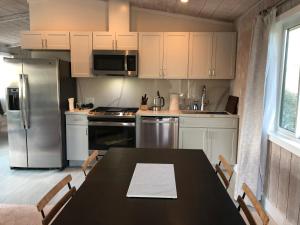 a kitchen with a black table and a refrigerator at Almost Eden Guesthouse in Carmel +7 photos