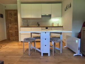 a kitchen with a white table and two stools at Cervino House in Breuil-Cervinia