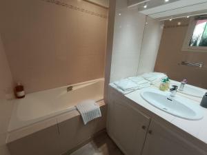 ein weißes Badezimmer mit Waschbecken und Badewanne in der Unterkunft studio cosy vue mer in Patrimonio