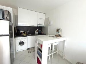 eine Küche mit weißen Schränken und einer Waschmaschine in der Unterkunft studio cosy vue mer in Patrimonio + 15 Fotos
