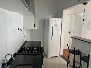 サンパウロにあるApartamento Premium Liberdadeのキッチン(コンロ、白い冷蔵庫付) +2枚の写真