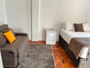 サンパウロにあるApartamento Premium Liberdadeのソファとベッドのあるリビングルーム