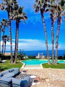 a resort with palm trees and a swimming pool at Villa Seba Sicily in Augusta