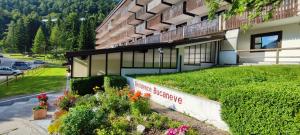 a building with flowers in front of it at Cuore Alpino in Chiusaforte