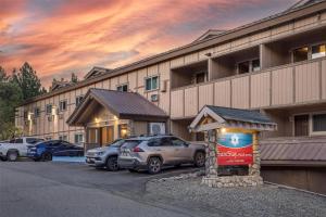 Un edificio con coches aparcados en un estacionamiento. en SureStay Plus Hotel by Best Western Mammoth Lakes, en Mammoth Lakes