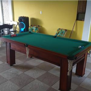 a pool table in a room with a green cloth at Pousada Summer Beach by Itaúna in Saquarema
