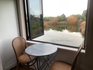 马斯特顿Bellevue Haven的窗前的一张桌子和两把椅子