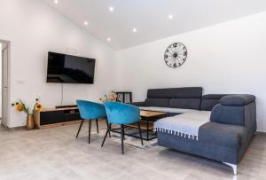 a living room with a couch and a table and a clock at Luksuzna kuća za odmor "Villa Romantica" in Kraljevica