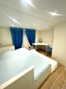 una camera da letto con un letto bianco e una scrivania di Havre de Paix proche Paris et Disney a Saint-Maur-des-Fossés
