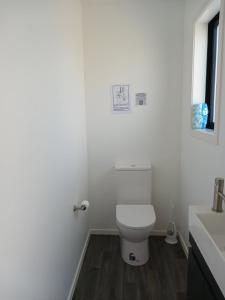 a white bathroom with a toilet and a sink at Suncrest Villas in Cromwell