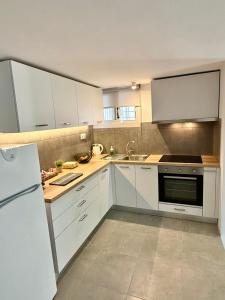 Una cocina con gabinetes blancos y un refrigerador blanco. en Christina's Home, en Atenas