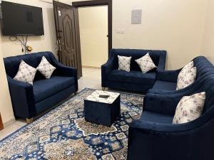 a living room with two blue couches and a tv at شقق بن طالب in Khamis Mushayt