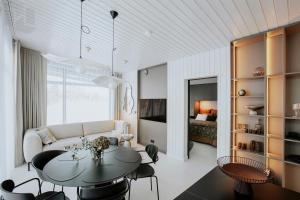 a living room with a table and a couch at Cliff House Joelahtme Golf Villa with Sauna in Manniva