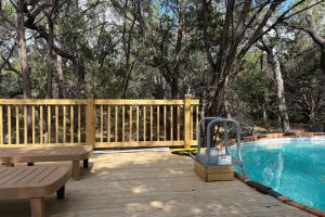 eine Holzterrasse neben einem Pool mit einer Bank in der Unterkunft Frontier Ranch Retreat and Cabin in Fischer