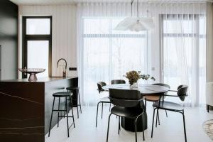 a kitchen and dining room with a table and chairs at Cliff House Joelahtme Golf Villa with Sauna in Manniva