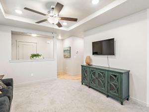 a living room with a ceiling fan and a tv at Heart of Nampa-Hot Tub-Fenced Yard-Full Kitchen in Nampa