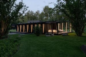 a modern house in a garden with trees and grass at Cliff House Joelahtme Golf Villa with Sauna in Manniva