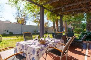 einen Tisch mit Stühlen und eine Tischdecke auf der Terrasse in der Unterkunft Buen Viaje Mendoza in Mendoza + 41 Fotos