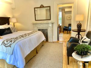 Un dormitorio con una cama y una chimenea. en Old Village Inn Ogunquit, en Ogunquit