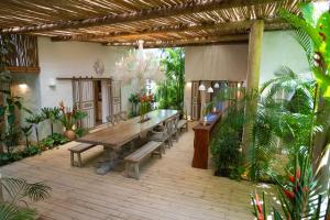 an outdoor patio with a wooden table and benches at Santa Fe Casas- Quadrado Trancoso in Trancoso