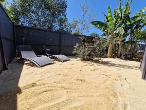 LéguevinにあるVilla entière avec piscine- 8pの柵の近くの砂の上に置かれた椅子のグループ