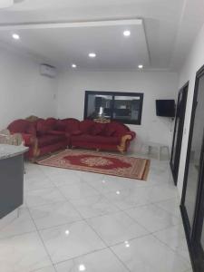 a living room with a red couch and a rug at villa with pool in Midoun