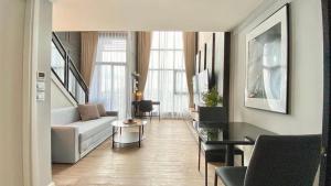 een woonkamer met een bank en een tafel bij Modiz Modiza Sukhumvit R4 in Bangkok +3 foto's