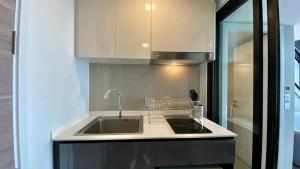 een keuken met een spoelbak en een aanrechtblad bij Modiz Modiza Sukhumvit R4 in Bangkok