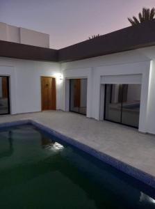 a house with a swimming pool in front of it at villa with pool in Midoun