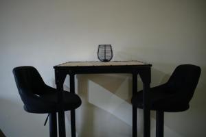 einem Tisch mit zwei Stühlen und einem Vogelkäfig darauf in der Unterkunft Aki Banda Suites in Willemstad + 3 Fotos