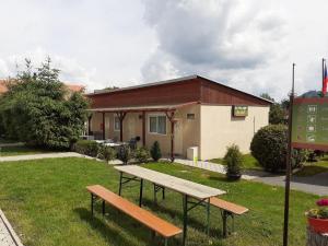 a bench in the grass in front of a building at Autocamp Free Star - Chatky a Bungalovy in Strachotín