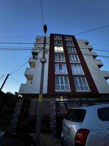 a building with a car parked in front of it at Rent&live calm place apartment in Crăsnăşeni