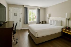 a hotel room with a bed and a desk at Days Inn by Wyndham Bradenton I-75 in Bradenton +8 photos