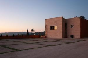 a brick building with a sunset in the background at Sky High Guesthouse in Gharīfah