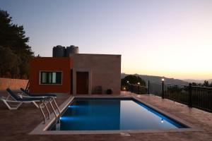 a swimming pool with two chairs and a house at Sky High Guesthouse in Gharīfah