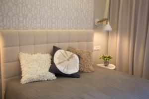 een slaapkamer met een bed met kussens erop bij Angel in Druskininkai