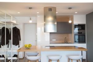 a kitchen with a wooden counter with stools at Angel in Druskininkai +8 photos